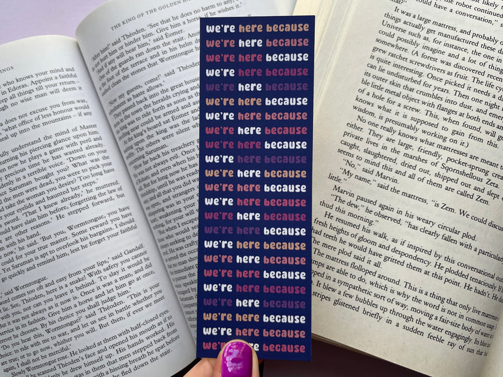 A blue bookmark with the repeating text "we're here because we're here" is shown held over a background of open books.