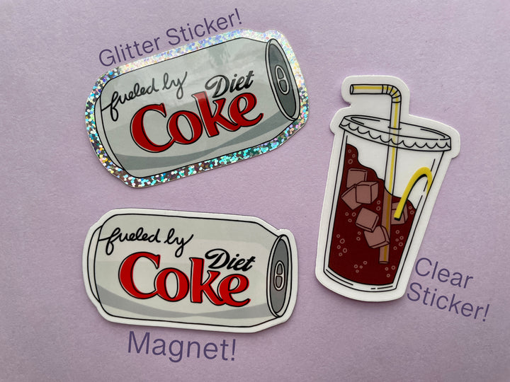 Three items on a purple background surrounded by objects. The items are a Diet Coke magnet, Diet Coke glitter sticker, and a fountain drink with bendy straw sticker.