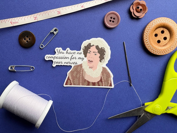 A cartoon of Mrs. Bennet from Pride and Prejudice 1995 with the text 'you have no compassion for my poor nerves'. The sticker is on a blue background surrounded by small sewing notions.