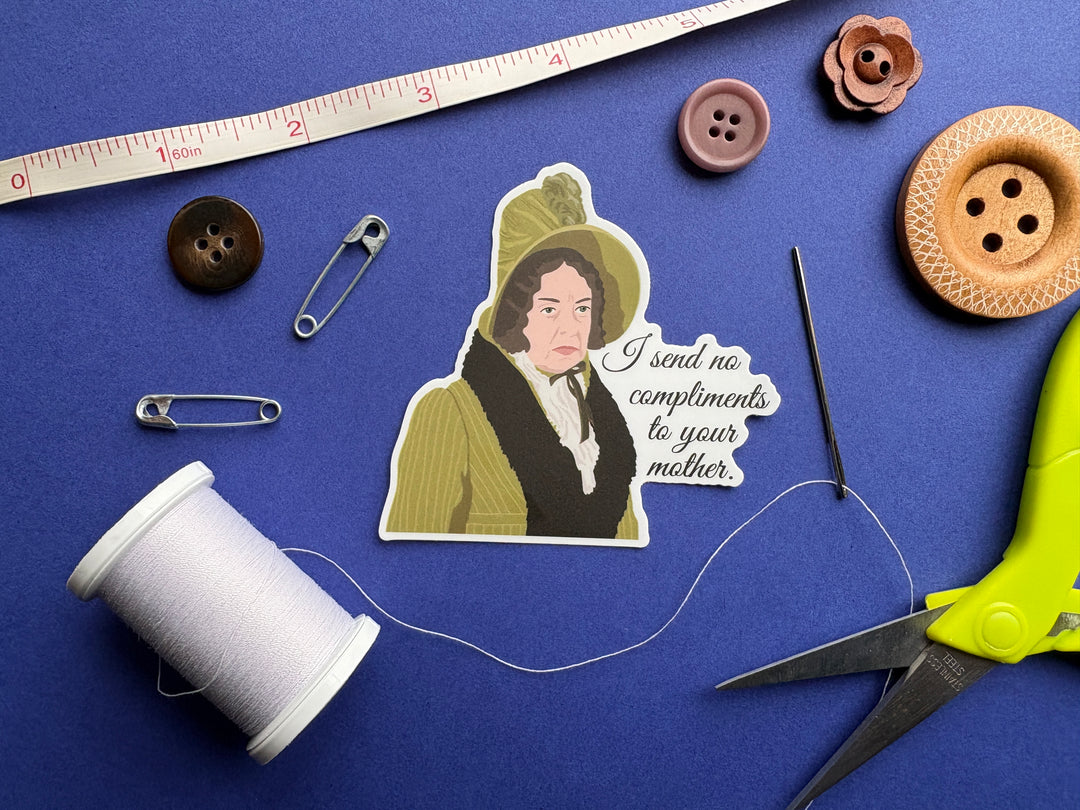 A cartoon of Lady Catherine from Pride and Prejudice 1995 with the text 'I send no compliments to your mother'. Resting on a blue background surrounded by small sewing notions.