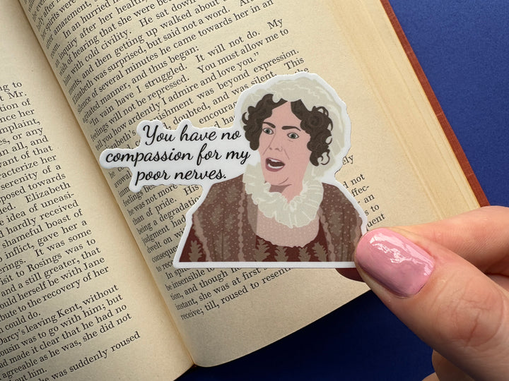 A cartoon of Mrs. Bennet from Pride and Prejudice 1995 with the text 'you have no compassion for my poor nerves'. The sticker is held above an open book resting on a blue background.