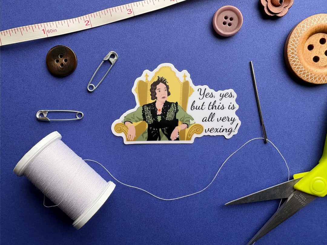 A cartoon of Lady Catherine from BBC Pride and Prejudice 1995 with the text 'yes, yes, but this all very vexing!'. She is sitting in a gold chair and wearing a green dress. The sticker is on a blue background surrounded by small sewing notions.