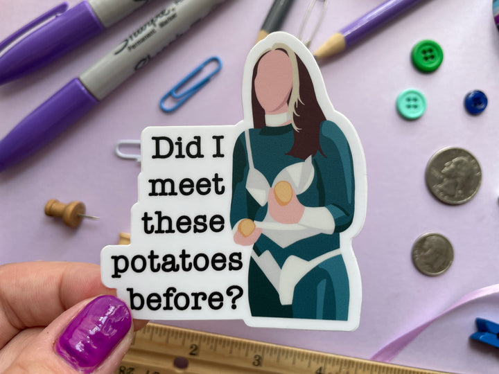 A sticker of a cartoon of comedian Fern Brady holding a potato on the TV show Taskmaster next to the text "Did I meet these potatoes before?" is held over a purple background covered in objects.