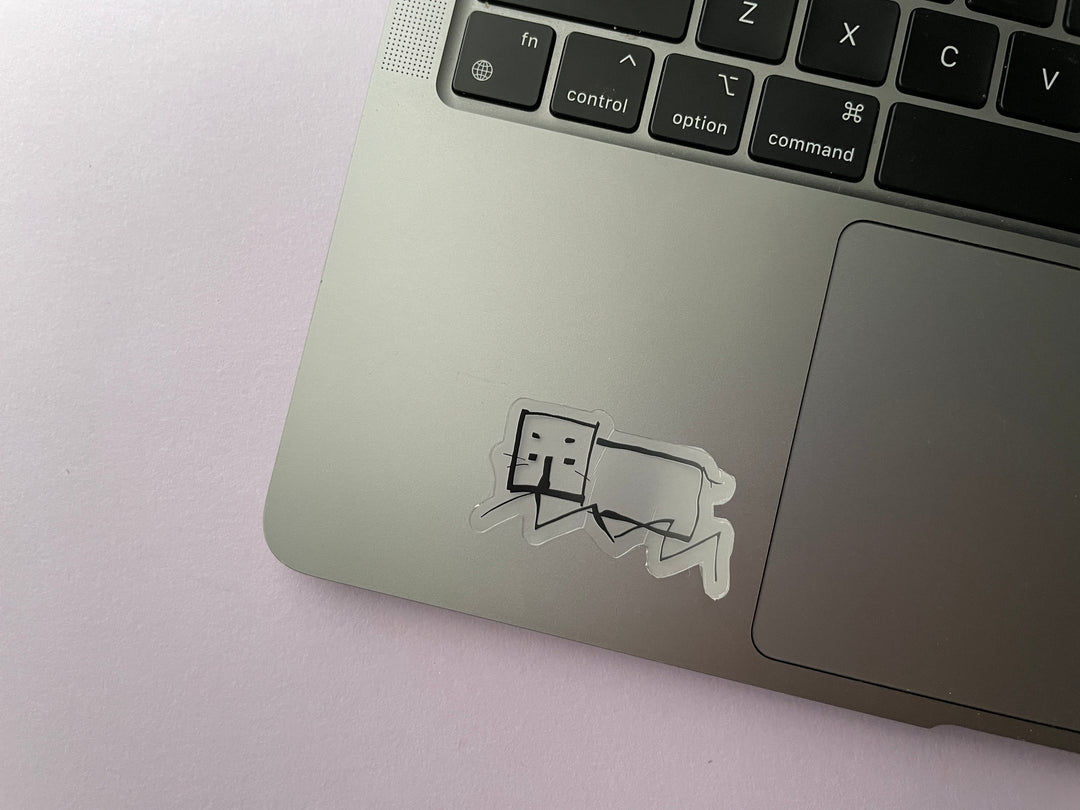 A sticker of a line drawing of a hippo as done by comedian Daisy Mae Cooper on the TV show Taskmaster is shown on a silver laptop.