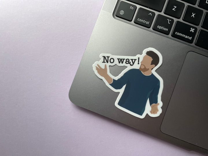 A sticker of comedian Chris Ramsey with his arms spread yelling "No way!" from the TV show Taskmaster is shown on a silver laptop.