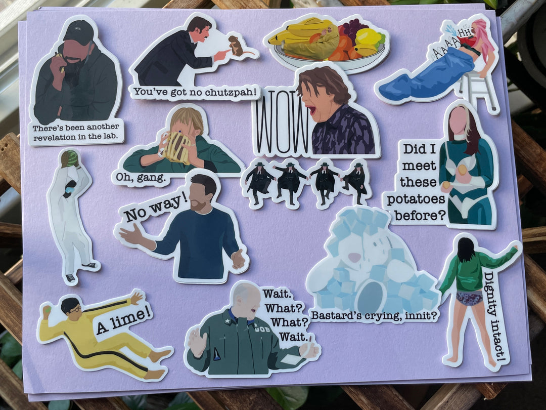 14 stickers depicting cartoon moments from the TV show Taskmaster are shown on a purple background.