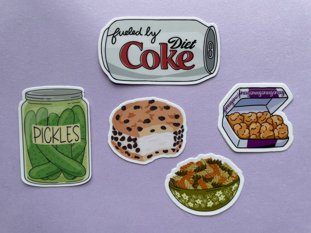 Five stickers are shown on a purple background. The stickers are a can of diet coke, a jar of pickles, a chocolate chip cookie ice cream sandwich, a purple and white box of chicken nuggets, and a green bowl of multi-colored spiral noodles.